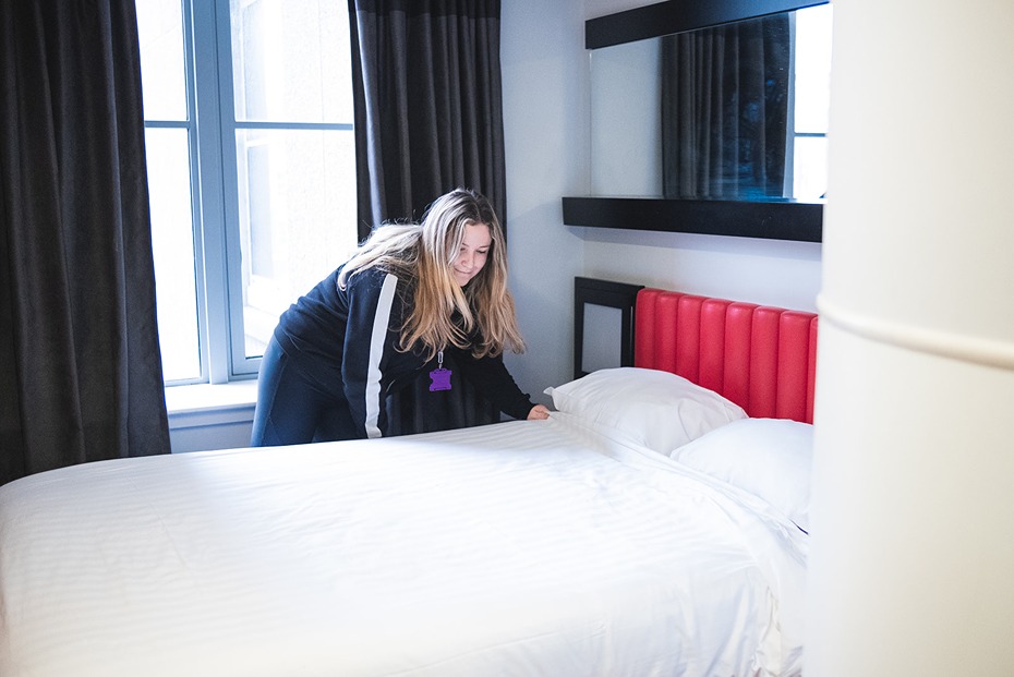 A member of staff prepares a clean and safe bed for a guest to spend the night