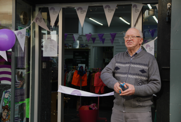 Founder of Bethany Christian Trust, Rev Alan Berry, cuts ribbon to celebrate opening of new shop in Glasgow.